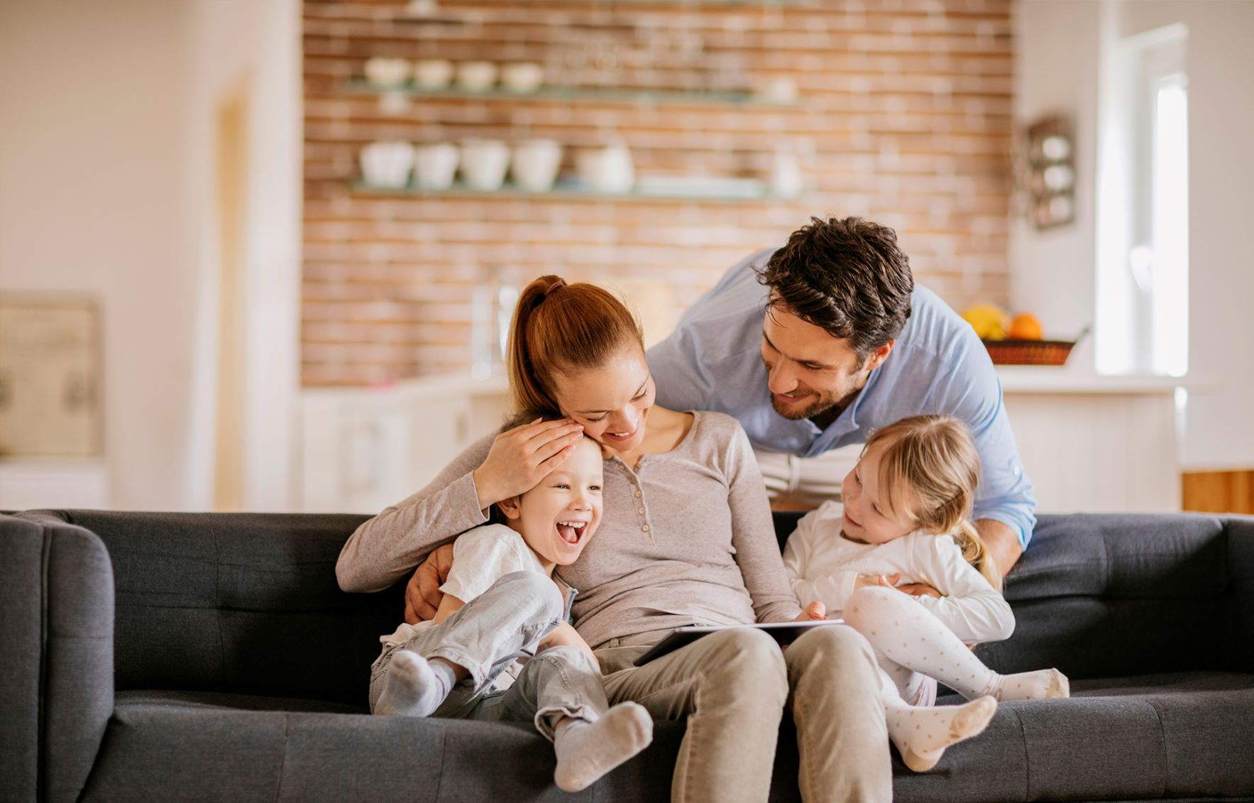 Family of four sitting on couch