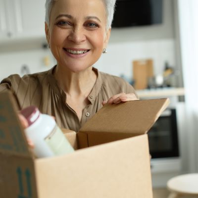 Person pulling a medicine bottle out of a cardboard box