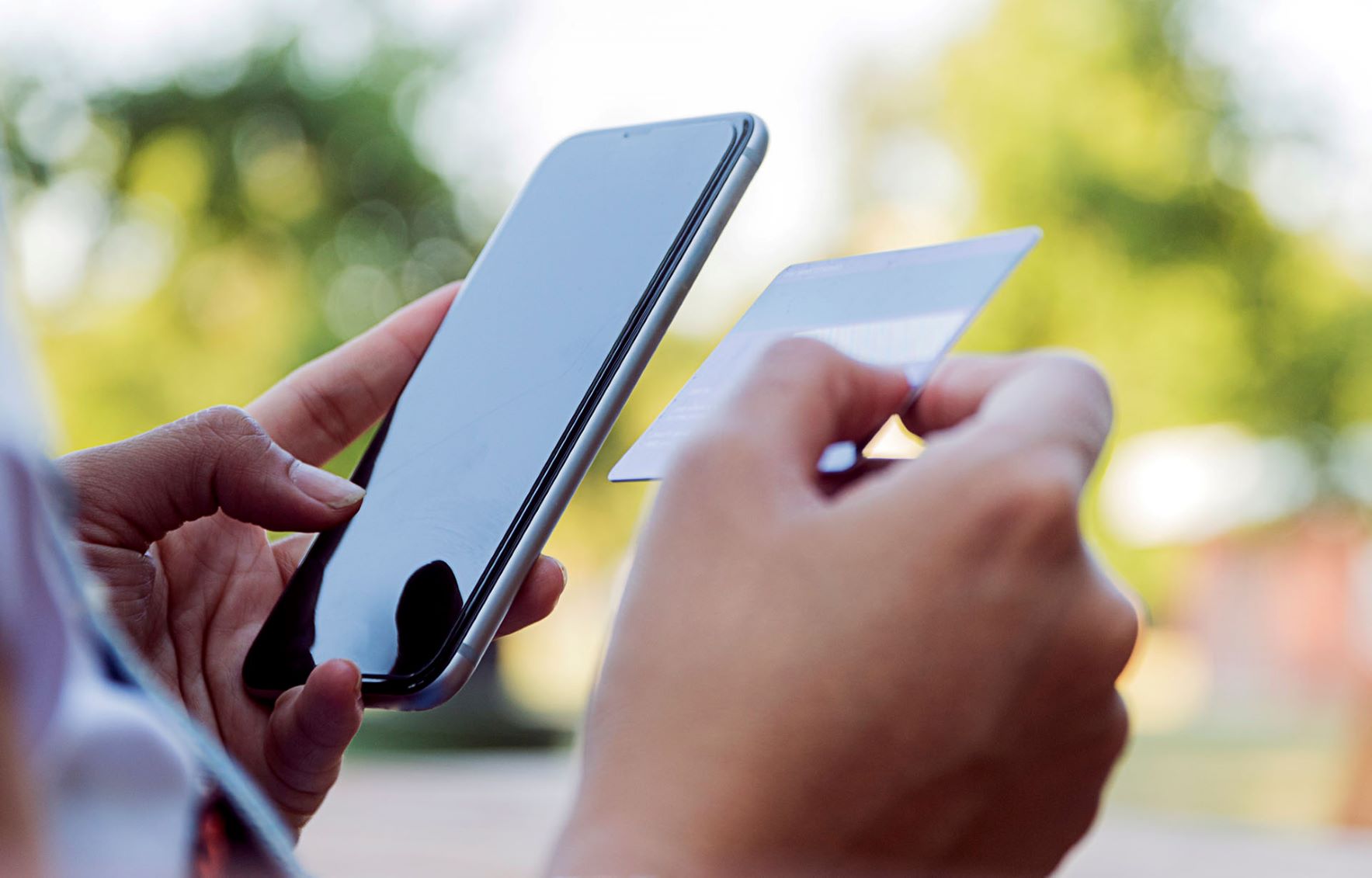 Person on phone looking at member ID card