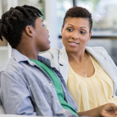 Boy in jean jacket talking to mom in yellow shirt